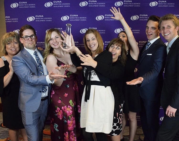 The marketing team celebrating with an award trophy at the CUNA Marketing and Business Development Council conference